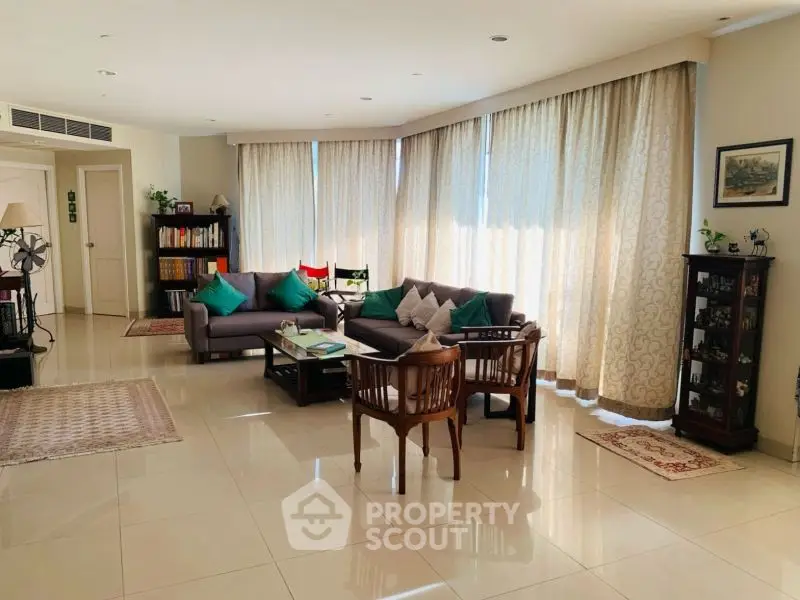 Spacious living room with elegant decor and natural light, perfect for relaxation and entertaining.