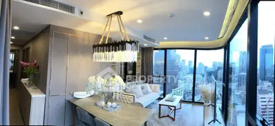 Luxurious modern living room with panoramic city views and elegant chandelier.