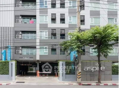 Modern apartment building exterior with secure entrance and lush greenery.
