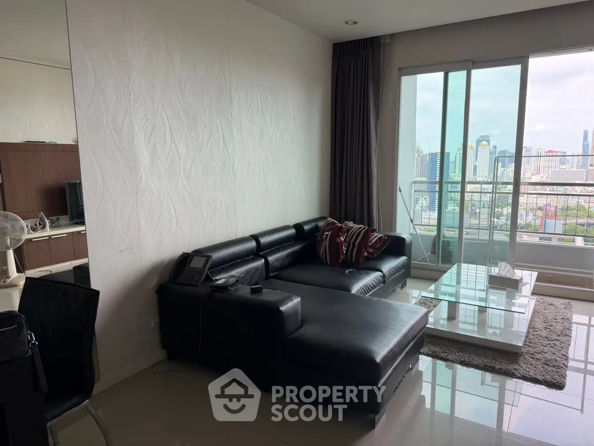 Modern living room with city view and sleek black leather sofa
