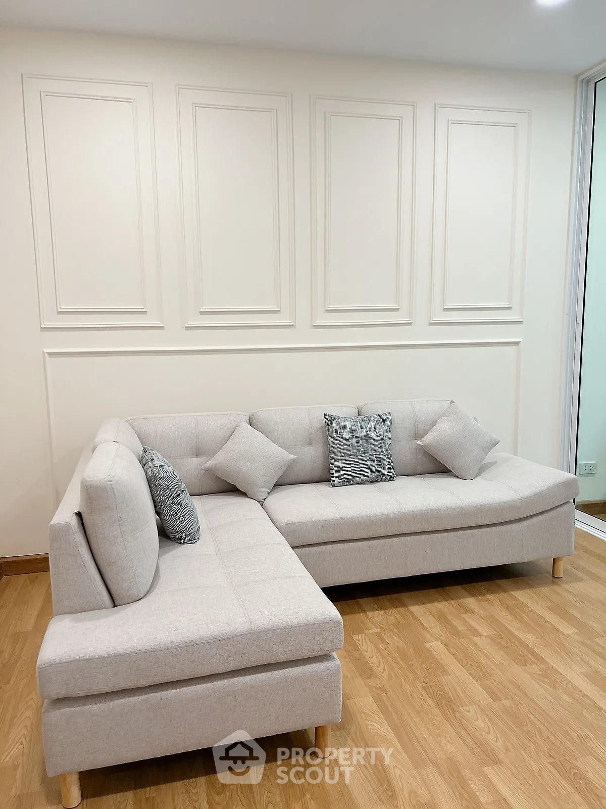 Elegant living room with modern L-shaped sofa and stylish wall paneling