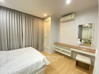 Cozy bedroom with modern decor, featuring a comfortable bed, air conditioning, and elegant curtains.