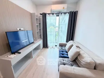 Modern living room with cozy sofa, large TV, and natural light from balcony window.
