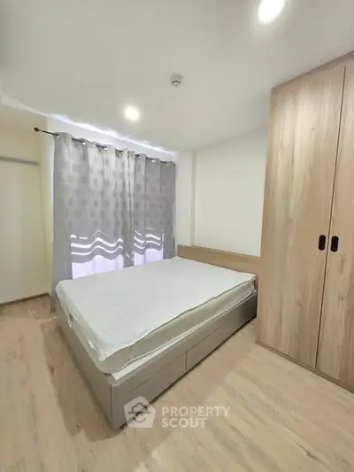 Modern bedroom with minimalist design, featuring a cozy bed and stylish wooden wardrobe.