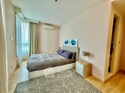 Spacious modern bedroom with large window and stylish decor in a luxury apartment.