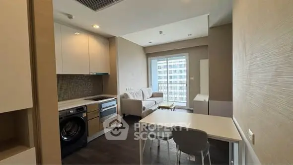 Modern apartment interior with open kitchen and living area, featuring sleek design and natural light.