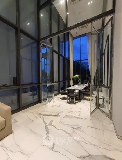 Luxurious high-ceiling living room with marble flooring and expansive windows