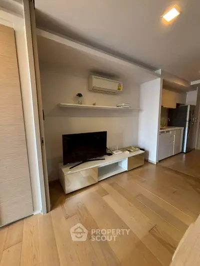 Modern living room with wooden flooring and sleek TV unit, perfect for cozy entertainment.