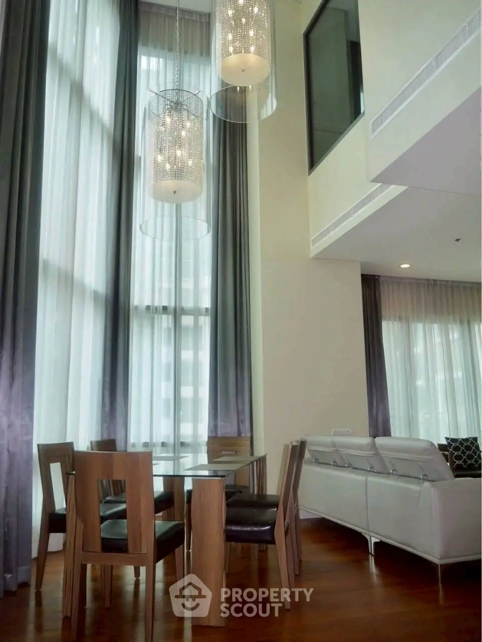 Luxurious high-ceiling living room with elegant dining area and modern decor