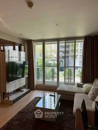 Spacious living room with large windows and modern decor in a stylish apartment.
