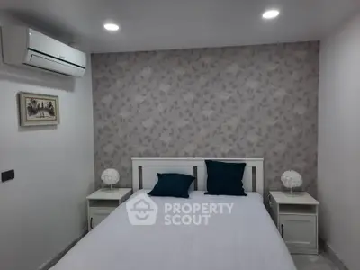 Cozy bedroom with stylish wallpaper and modern air conditioning unit.