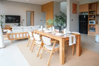 Modern open-plan living and dining area with stylish wooden furniture and natural light.