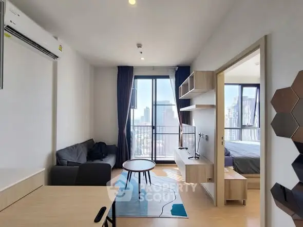 Modern apartment living room with city view, stylish furniture, and natural light.