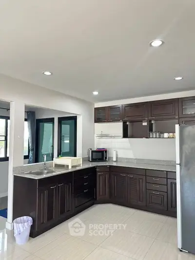 Modern kitchen with dark wood cabinets and sleek countertops