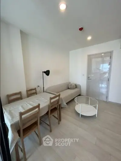 Cozy living room with dining area, featuring modern furniture and bright lighting.