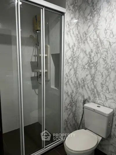 Modern bathroom with marble walls and glass shower enclosure