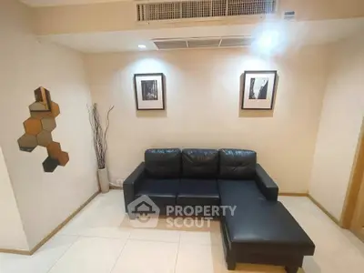 Stylish living room with black leather sofa and modern wall art