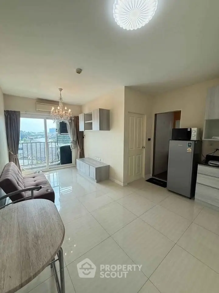 Modern living room with balcony view, stylish chandelier, and sleek furnishings in a bright apartment.