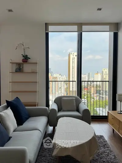 Modern living room with large windows offering stunning city views, cozy seating, and elegant decor.