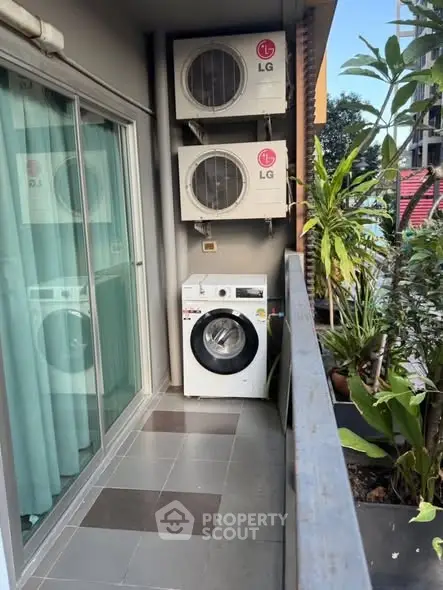 Charming balcony with washing machine and lush greenery, perfect for urban living.
