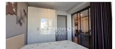 Modern bedroom with sleek wardrobe and stylish decor in a contemporary apartment.