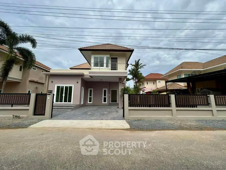 Modern two-story house with spacious driveway and stylish fence