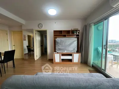 Spacious living room with modern decor and balcony view in a high-rise apartment.