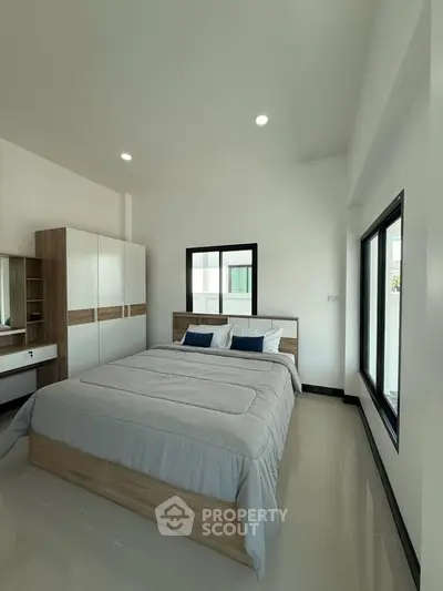 Modern bedroom with sleek design, featuring a comfortable bed and stylish wardrobe in a bright, airy space.