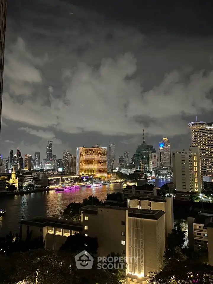 Stunning nighttime cityscape view with illuminated skyline and river reflections.