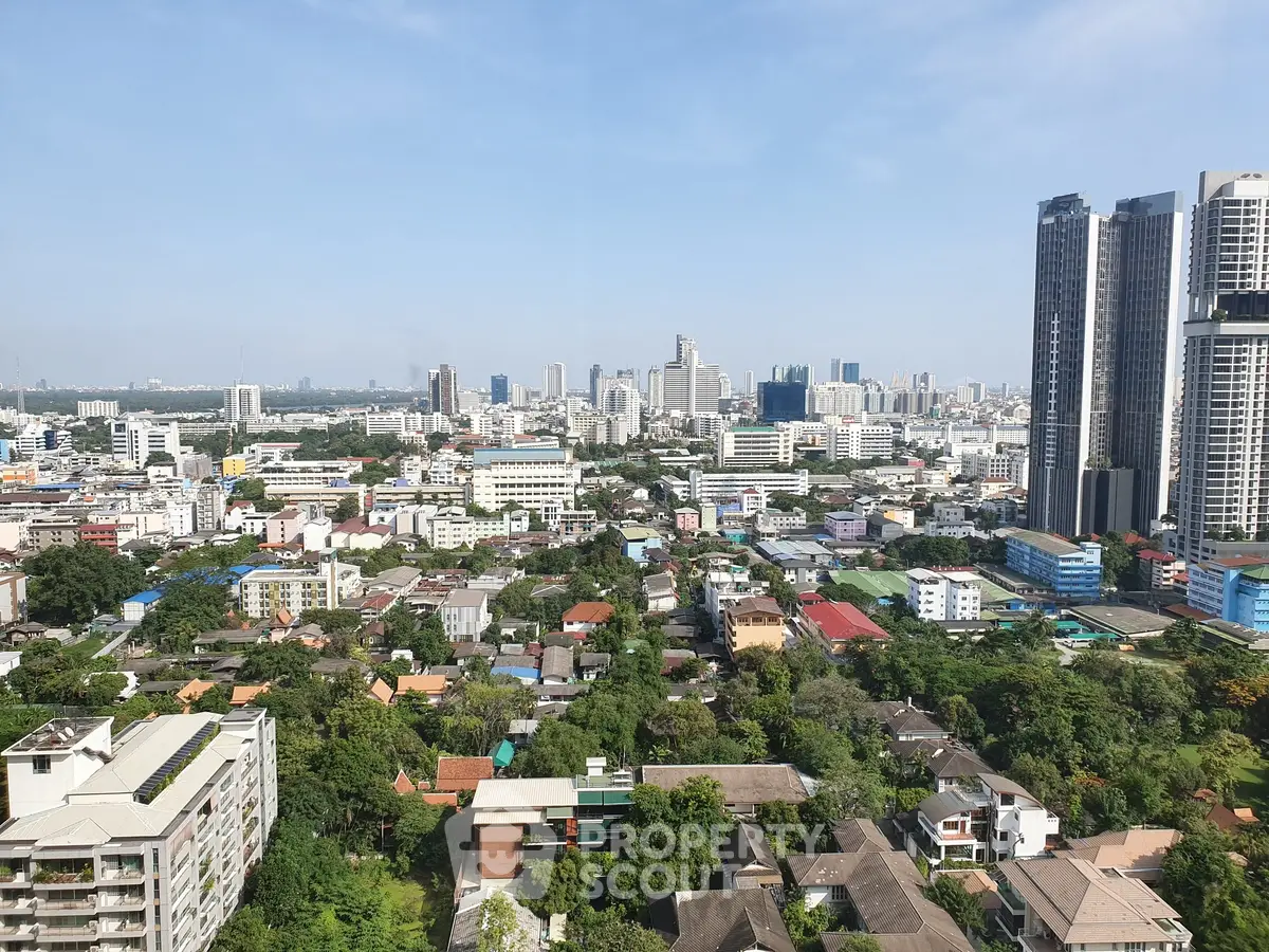 Stunning cityscape view from high-rise apartment showcasing urban skyline and lush greenery.