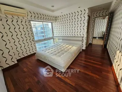 Spacious bedroom with modern design and large windows offering city views.