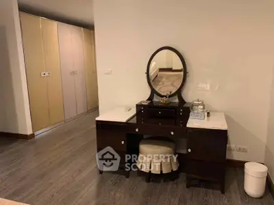 Elegant bedroom with stylish vanity and spacious wardrobe in modern apartment.