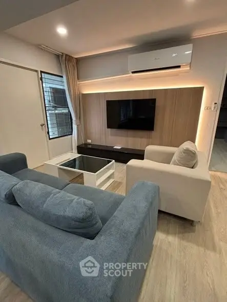 Modern living room with stylish furniture and wall-mounted TV