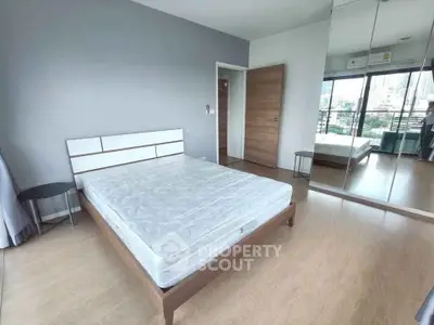 Spacious bedroom with city view and mirrored wardrobe in modern apartment