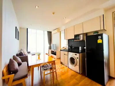 Modern open-layout kitchen and living room with washing machine and fridge