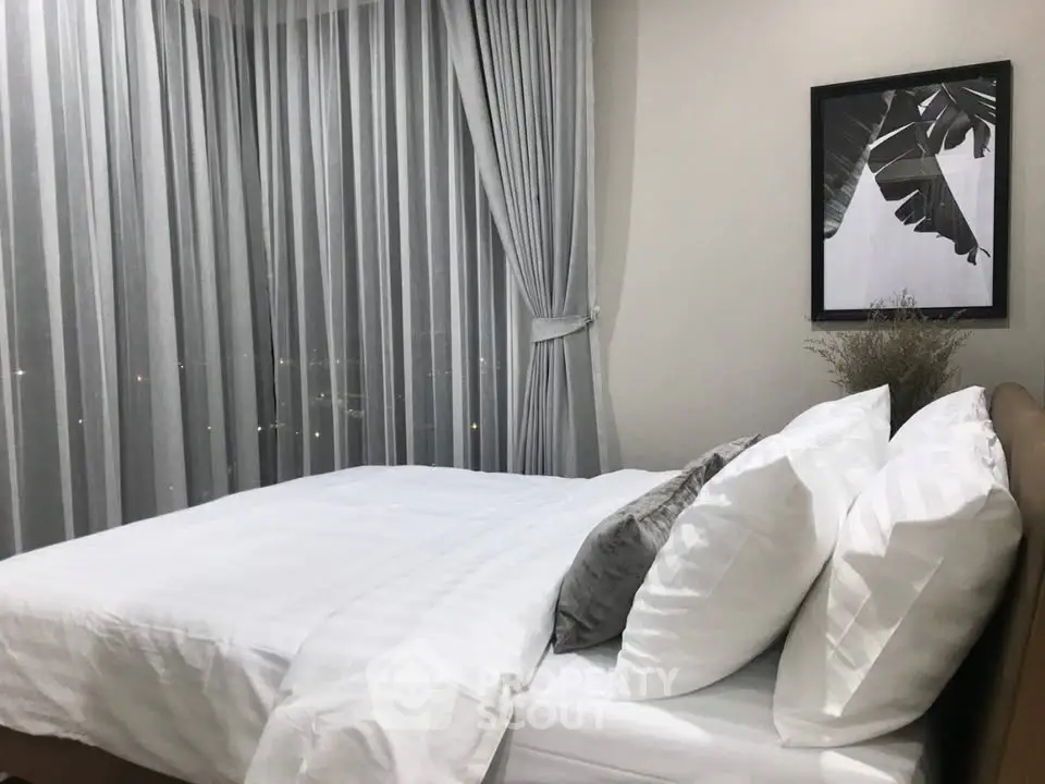Elegant bedroom with modern decor and large windows offering city views.