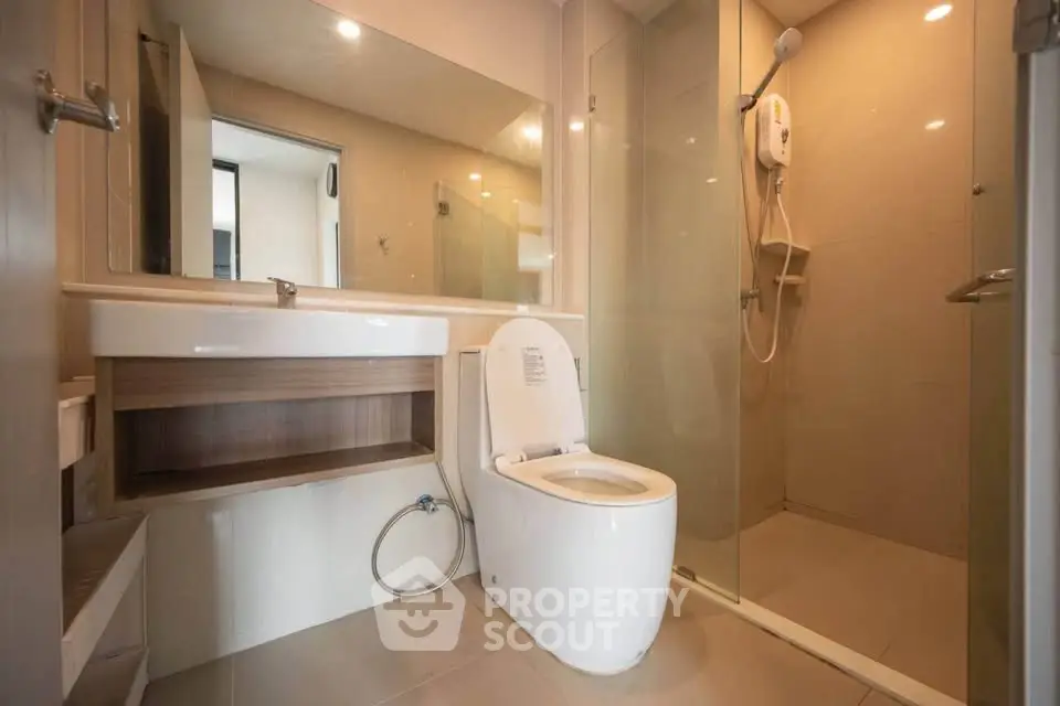 Modern bathroom with glass shower and sleek fixtures in a contemporary apartment.