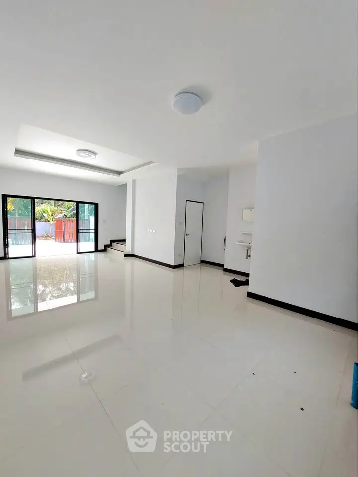 Spacious modern living room with glossy white tiles and large windows