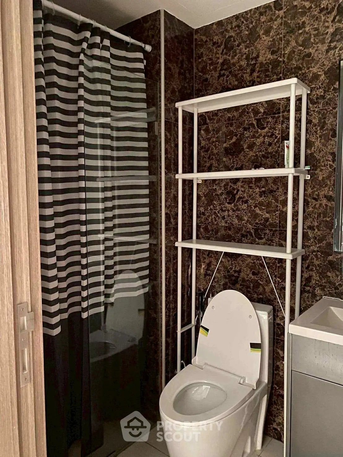 Modern bathroom with sleek design featuring a glass shower and stylish shelving.