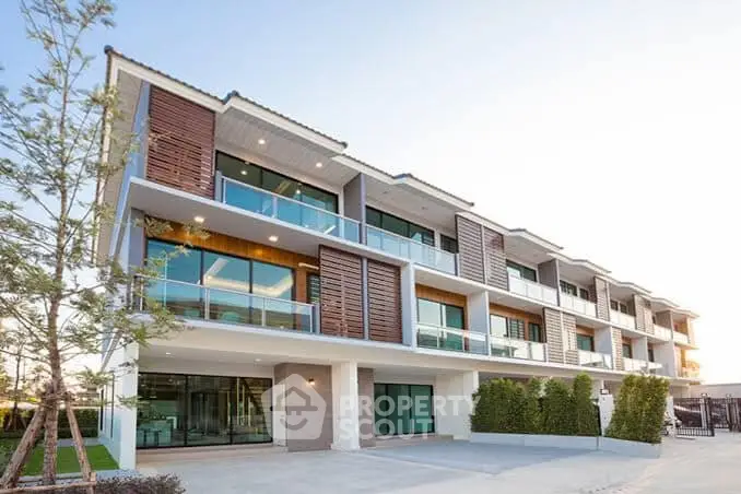 Modern multi-story apartment building with large balconies and stylish facade.