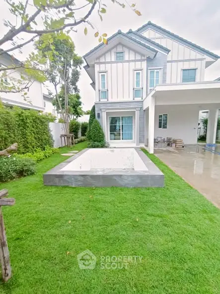 Charming modern home with lush green lawn and unfinished pool in serene neighborhood.