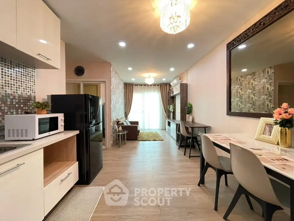 Modern open-layout kitchen and living area with elegant decor and ample natural light.