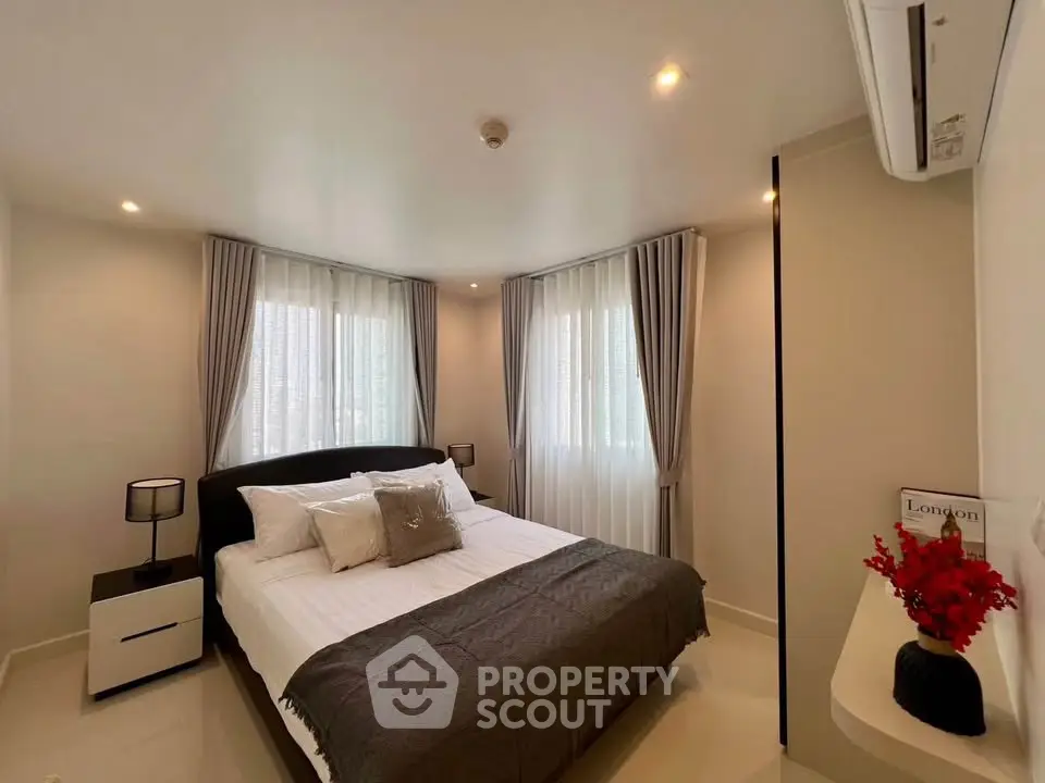 Modern bedroom with elegant decor and natural light, featuring a cozy bed and stylish curtains.