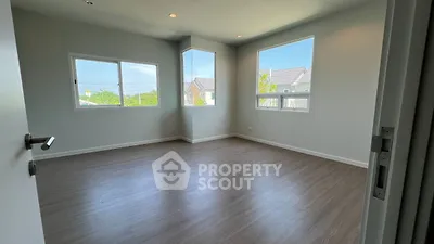 Spacious empty room with large windows and wooden flooring, perfect for customization.