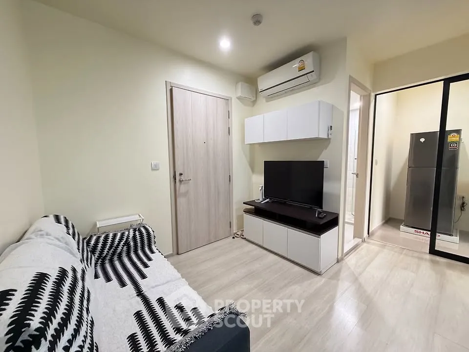 Modern living room with sleek design, featuring a cozy sofa, wall-mounted TV, and air conditioning unit.