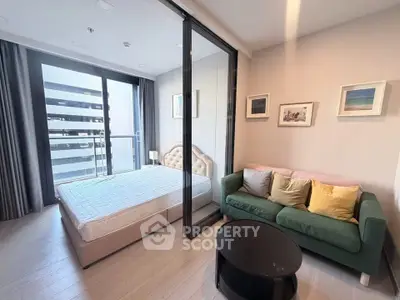 Modern bedroom with glass partition and cozy seating area in a stylish apartment.