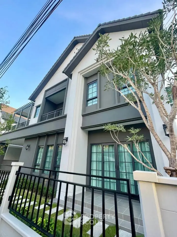 Elegant modern house exterior with lush greenery and stylish architecture.