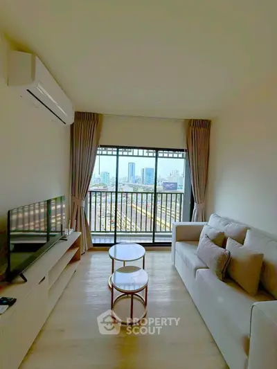 Modern living room with city view, featuring cozy sofa and sleek TV setup, perfect for urban living.
