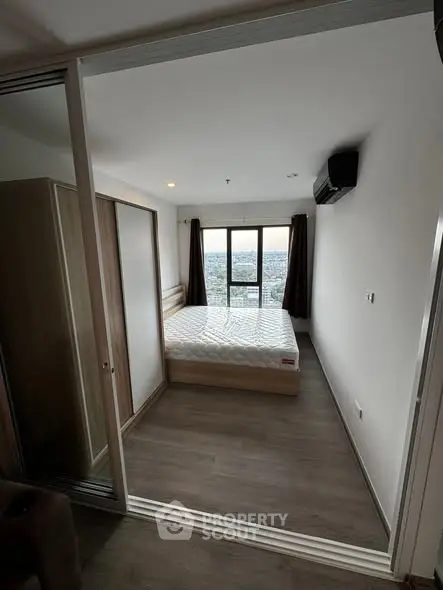 Spacious bedroom with large window offering stunning city views.