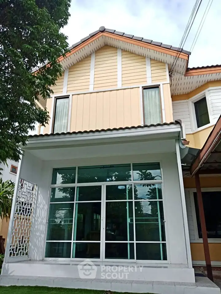 Charming two-story house with modern facade and large windows in a serene neighborhood.